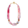 A statement pink necklace made of silk and glass.